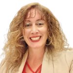 Photo of Denise Russo, Ed.D. Student. She is wearing a tan jacket and has curly hair.