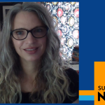 Melissa Fiori wears black frame glasses with blonde wavy hair down and smiles.