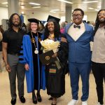 A group of people pose together at a graduation ceremony.