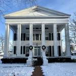 A photo of Clarke House in winter with wreaths adorning the columns