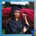 Desiree Charles in cap and gown holds a tassel while posing outdoors, with bright red flowers blurred in the background; graphic includes a logo in the top left and “Class of 2026” in the bottom right.