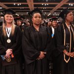 A group of graduates watch the commencement ceremony