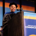 Melba Tolliver poses in front of an Empire State University podium.