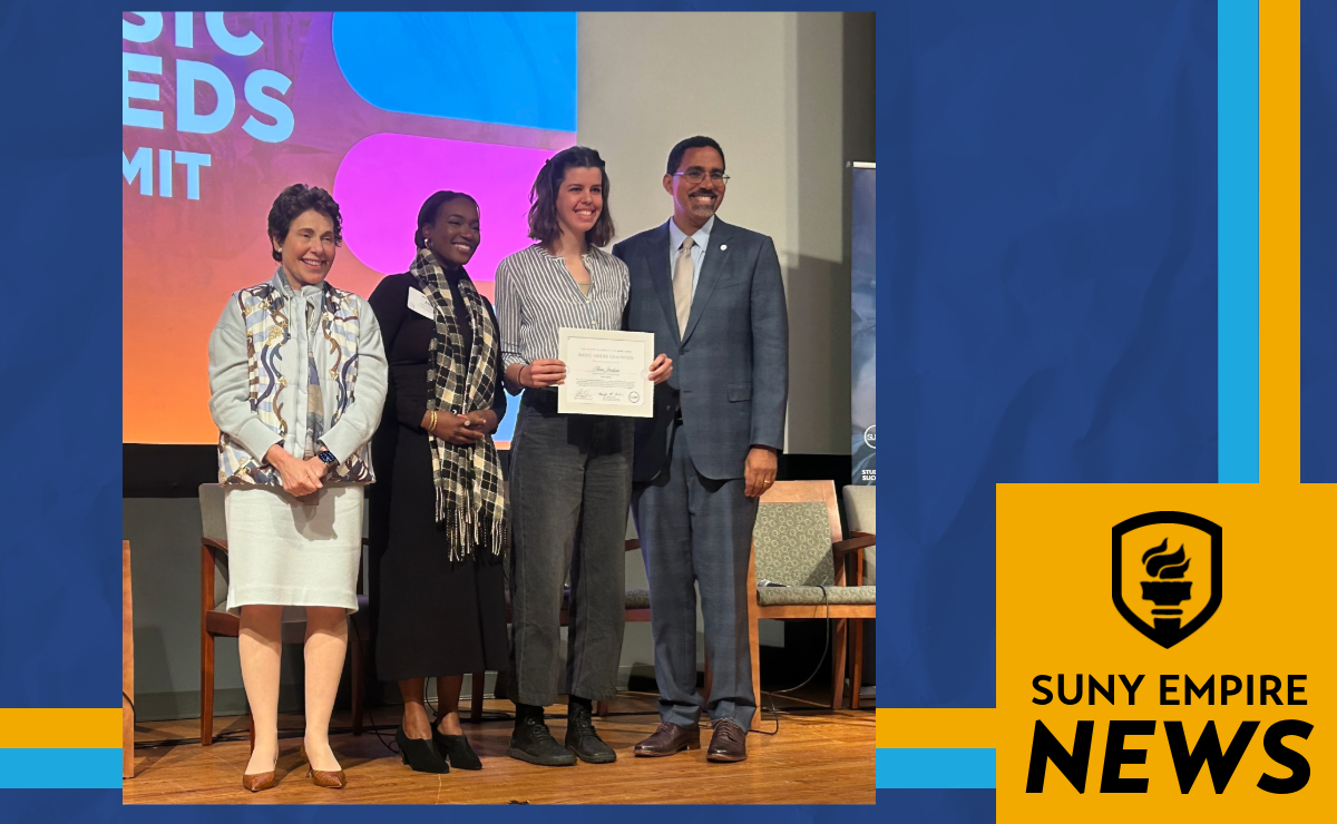 Four people stand on a stage during an award presentation, with Basic Needs Coordinator Anna Zoodsma holding a certificate. A colorful event backdrop is behind them, and a SUNY Empire News graphic appears on the right side of the image.